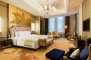 赤峰赤峰富力万达嘉华酒店的一间卧室配有一张大床和一个吊灯。