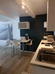 马赛城市之海公寓的厨房配有水槽和桌椅