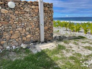 TemaeMoorea Lodge的海边的石墙,有杆
