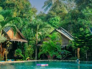班泰Munchies Bungalows的棕榈树度假村前的游泳池