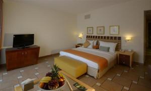 Al Qulay‘ahSeashell Julai'a Hotel & Resort Family resort的酒店客房,配有一张床和一碗水果
