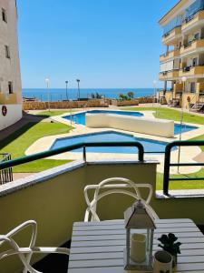 贝纳尔马德纳Apartment Sea Breeze – Apartamento Brisas del Mar的一个带游泳池的阳台的桌椅