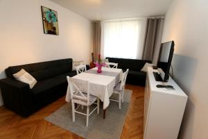 杜布罗夫尼克Apartment Mira Lapad的客厅配有白色桌子和黑色沙发