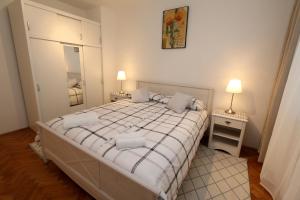 杜布罗夫尼克Apartment Mira Lapad的一间卧室配有一张床、两盏灯和一面镜子