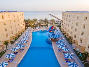 赫尔格达AMC Royal Hotel & Spa的享有带蓝伞的度假村游泳池的顶部景致