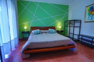 墨西拿B&B CasaBuddace的一间卧室配有一张带绿色墙壁的床
