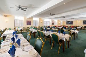 韦茅斯皇冠酒店的宴会厅配有白色的桌椅