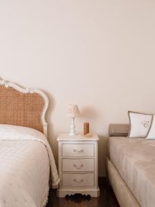 马尔米堡Villa Diletta b&b的一间卧室配有两张床和一个带灯的床头柜。