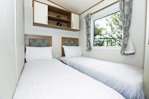 HumberstonCleethorpes Pearl Holiday Park的小型客房 - 带2张床和窗户