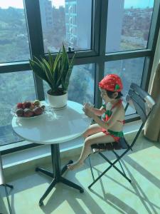 岑山Tuấn Đạt Luxury FLC Sầm Sơn的坐在桌子旁的椅子上的娃娃
