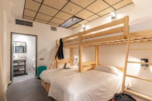 毕尔巴鄂Ekoos Hostel, Bilbao Eko Hostel的一间带双层床的卧室和一间浴室