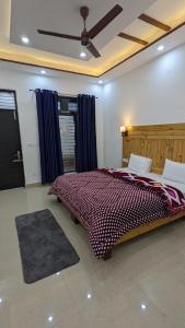 恰克拉塔HOTEL HIMALAYAN FOXHOLE的一间卧室配有一张带蓝色窗帘的大床