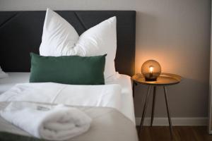 吕贝克HejU - Parking - Kitchen - Netflix - Kingsize Bett的一张带白色枕头的床和一张桌子上的蜡烛
