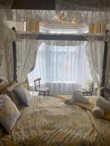 布莱克浦Riversvale Hotel的一间卧室配有一张带天蓬和窗户的床