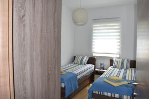 杜布罗夫尼克Apartment Vapor的一间卧室设有两张带蓝色床单的床和窗户。
