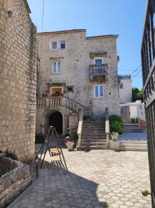 特罗吉尔Studios Kadena Trogir - 18th century stone house的一座大型石头建筑,前面有楼梯