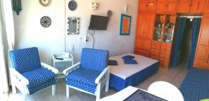 滨海罗克塔斯Estudio Frente Al Mar的配有床和两把椅子及一张桌子的房间