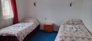 Bogazkale巴伊卡尔酒店的一间卧室设有两张床和床头柜