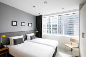 曼彻斯特曼彻斯特皮卡迪利星城公寓式酒店的酒店客房设有两张床和窗户。