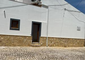 AlmádenaCasa Arenga的白色的建筑,设有门和两扇窗户