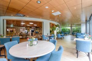 西泰尔斯海灵西科尔波什里克公寓酒店 的一间带桌子和蓝色椅子的用餐室