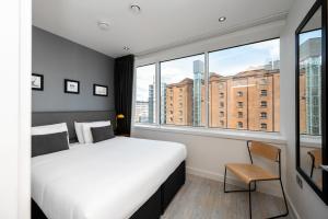 曼彻斯特曼彻斯特皮卡迪利星城公寓式酒店的酒店客房设有床和窗户。