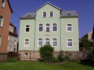 巴特尚道Ferienwohnung Lilienstein的绿色和白色的大房子,带围栏