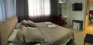 巴拉韦利亚Vila Alaide Praia Hotel的一间卧室配有一张床,上面有两条毛巾
