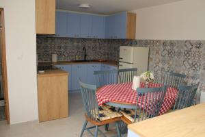 ErdutCOUNTRY HOUSE ERDUT的一间带桌椅的厨房和一间带蓝色橱柜的厨房