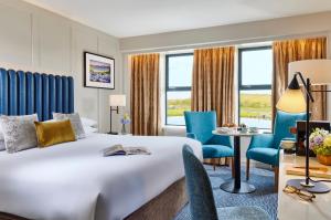 韦斯特波特西港海岸酒店 的酒店客房带一张床、一张桌子和椅子