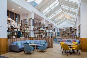 阿什福德Ashford International Hotel & Spa的图书馆配有蓝色的沙发、椅子和桌子