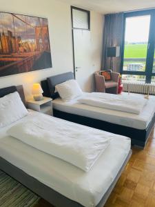科隆Messe Apartment Köln West的酒店客房设有两张床和窗户。