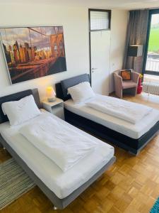 科隆Messe Apartment Köln West的一间设有两张床和椅子的房间