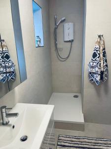 伦敦Central London stylish newly decorated studio flat的浴室配有白色水槽和淋浴。