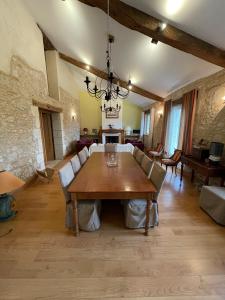 Saint-AntoineLA FERME DE VILLENEUVE的一个带木桌和椅子的大客厅