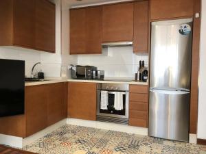 拉科鲁尼亚Yuhom casas con alma Galera 4º的厨房配有木制橱柜和不锈钢冰箱。