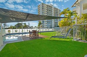 穆卢拉巴穆鲁拉巴海滩俱乐部度假酒店的一个带桌椅的庭院和一个游泳池