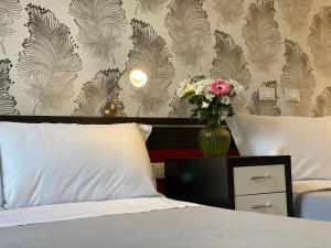 米兰米兰罗索维诺酒店的一间卧室,配有一张带花瓶的床
