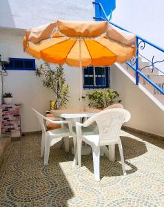 沃利迪耶Maison de la Lagune的庭院内桌椅和遮阳伞