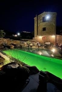 San Mauro CastelverdeAntico Borgo Buonanotte的一座建筑前的绿色水游泳池