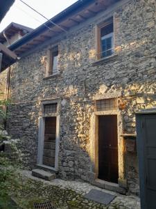 莱泽诺Antica Calvasino的一座古老的石头房子,前面有两扇门