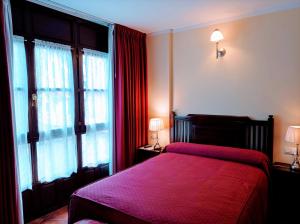 克尤卡萨裴蕾茵乡村民宿的一间卧室配有一张红色的床、两盏灯和窗户