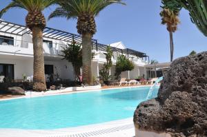 卡门港罗斯杜里班斯酒店的棕榈树屋前的游泳池