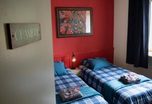 ChavanacLe Balcon Bleu, gîte located in Millevaches National Park的红色墙壁客房的两张床