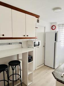 比韦罗Viveiro-Lugomar的厨房配有白色橱柜和白色冰箱。