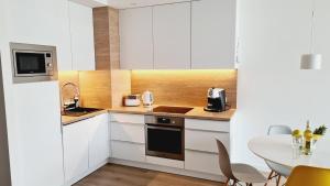 里沃Apartament Klifowa Rewal 16的厨房配有白色橱柜和桌子