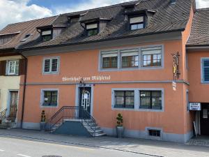 施泰因Garni-Hotel Mühletal的一座橙色的建筑,前面有楼梯