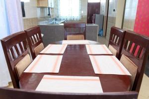 蒙巴萨SERENE 4 BEDROOMED HOME IDEAL FOR FAMILY HOLIDAY的一张带四把椅子的木桌和厨房