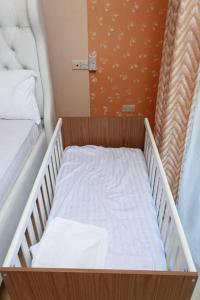 蒙巴萨SERENE 4 BEDROOMED HOME IDEAL FOR FAMILY HOLIDAY的一张小婴儿床,位于带两张床的房间