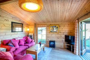 OareWillowbank Lodges的客厅配有粉红色的沙发和电视